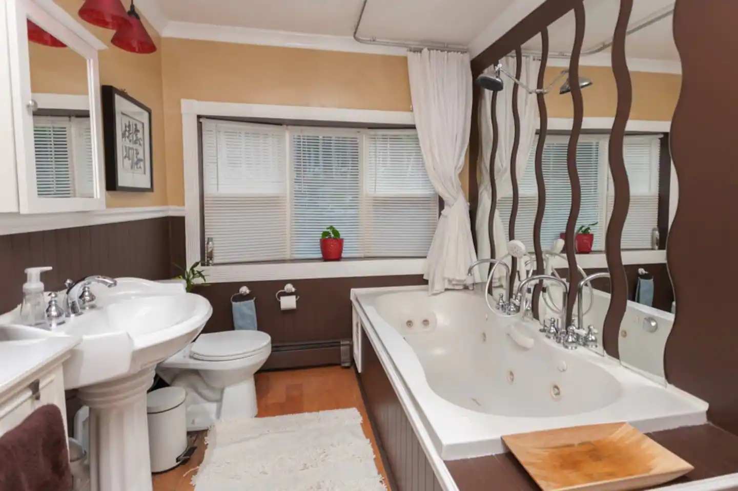 Bathroom with two pedestal vanities, jetted tub; bay window onto private back yard